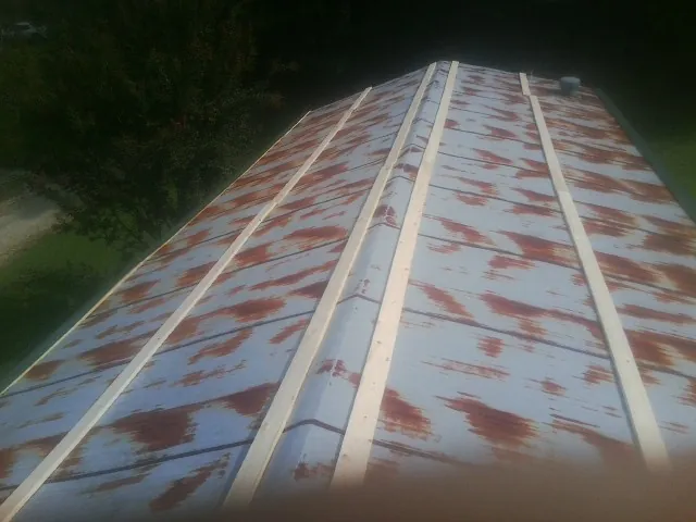 Rusted metal roof panels with new wood purlins before replacement — Storm Damage Roof Repair in Mount Hope by Roofing Brothers