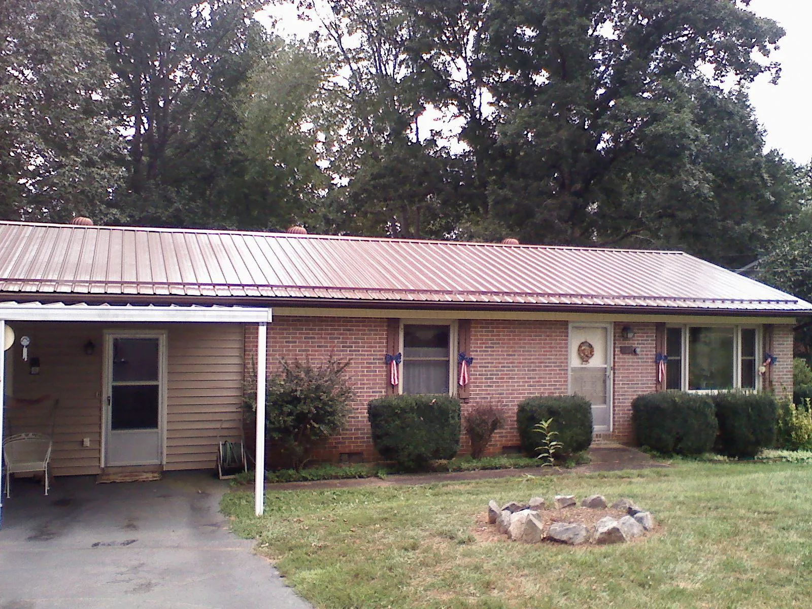 Bronze metal roof and carport on a brick ranch home — Roof Repair work by our crew in Mount Hope